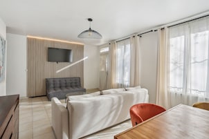 Apartamento família, 2 quartos | Área de estar | Smart TV 55 cm com canais digitais, TV