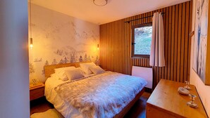 Une chambre à coucher avec un lit, une table de chevet et une fenêtre avec des rideaux.