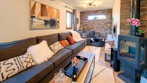 Un salon moderne avec un canapé, une table basse et une cheminée.