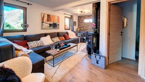 Un salon moderne avec un canapé, une table basse et une cheminée.
