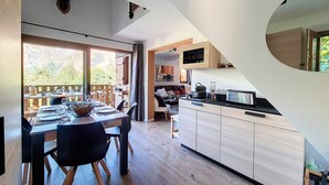 Une cuisine moderne dotée d’un grand îlot central, de planchers en bois et offrant une vue sur l’extérieur.