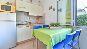 Une cuisine compacte comprenant un coin repas, un four à micro-ondes, une cuisinière et une fenêtre donnant sur un paysage agréable.