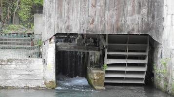 Un pont en béton avec un canal d’eau en dessous, entouré de verdure.