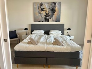 A modern bedroom with a large bed, two bedside tables, and a wall-mounted artwork. - Apartment Lotus 486 with Shared Pool, Terrace & Wi-Fi (LA CALA DE MIJAS)