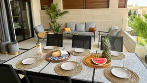 A dining area with a table set for two, featuring woven placemats, plates, and a variety of food items. - Apartment Lotus 486 with Shared Pool, Terrace & Wi-Fi (LA CALA DE MIJAS)