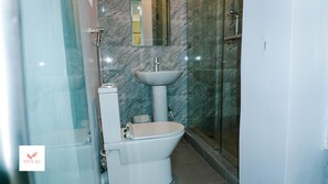 A modern bathroom with a toilet, sink, and shower. - Whitevill Hospitality and Homes (Ibadan)