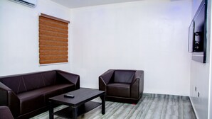 Una sala moderna con un sofá, un sillón y una mesa de centro.
