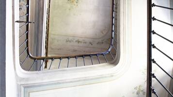 A spiral staircase with ornate railings and floral patterns on the walls.
