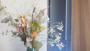 A vase with a floral arrangement of various flowers and leaves.