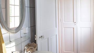 Un baño con lavamanos blanco, un espejo y una puerta.