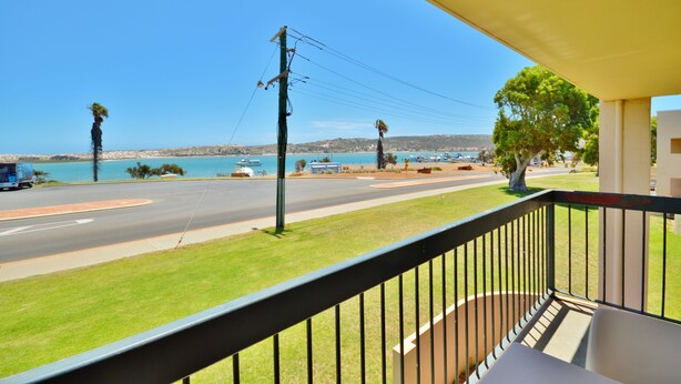 A balcony with a view of a road, a beach, and a body of water. - Riverview Holiday Waterfront Apt 23 - 1st Floor - Kalbarri WA (KALBARRI)