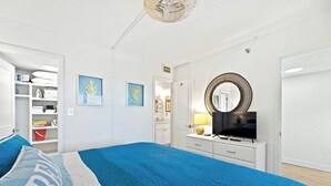 A bedroom with a large bed, a TV, a dresser, and a wardrobe. - 🏖️Oceanfront Sunrise Overlooking Pool!  Car Free Beach, Walk to shopping & dining! Sunrise 805 (New Smyrna Beach)