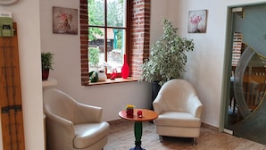 A cozy corner with two chairs, a small table, and a potted plant.
