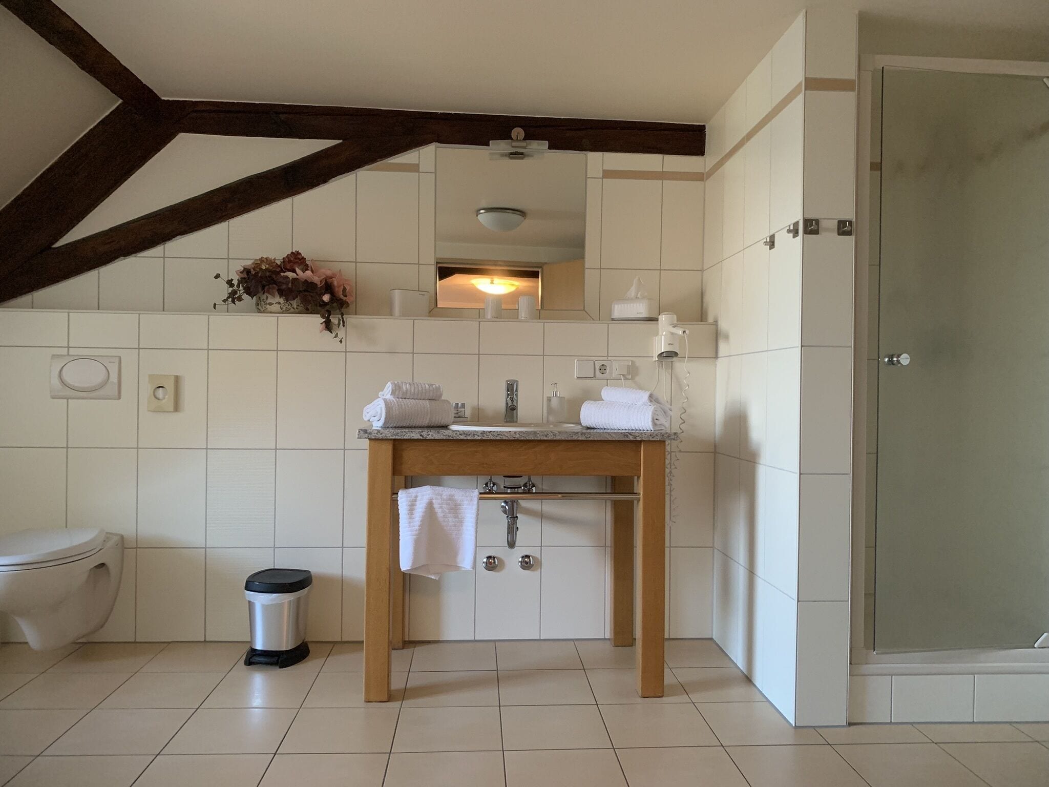A modern bathroom with a toilet, sink, and shower.