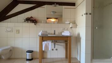 A modern bathroom with a toilet, sink, and shower.