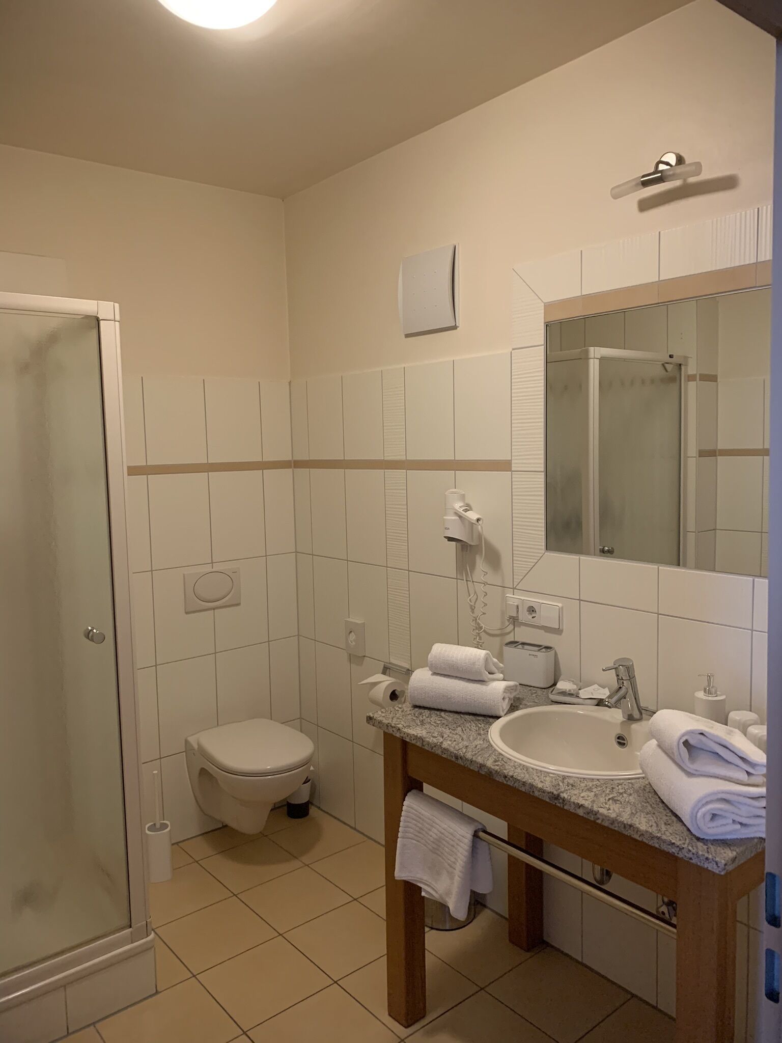 A modern bathroom with a toilet, sink, and shower.