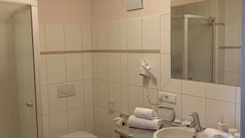A modern bathroom with a toilet, sink, and shower.