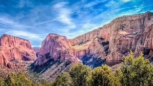 A canyon landscape with prominent rock formations and a clear sky.