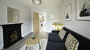 Ein modernes Wohnzimmer mit Kamin, einer Couch und einem Couchtisch.