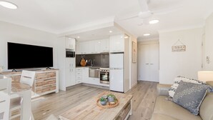 A modern apartment with a kitchen, dining area, and living room.