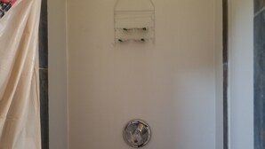 Eine Dusche mit Glastür, Handtuchhalter und Duschkopf.