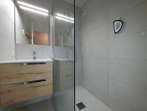 A modern bathroom with a glass shower enclosure, a white tiled wall, and a wooden vanity with a mirror. - 100m from ski slopes, 2nd floor, view mountain, balcony, ski locker, 28m², Valmorel (Valmorel)