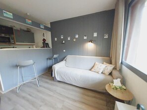 A compact living space with a kitchenette, a sofa, a small bar stool, and a bedside table. - 100m from ski slopes, 2nd floor, view mountain, balcony, ski locker, 28m², Valmorel (Valmorel)