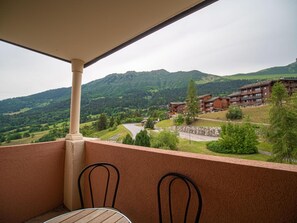 A balcony with a view of a mountainous landscape and a building with multiple floors. - 100m from ski slopes, 2nd floor, view mountain, balcony, ski locker, 28m², Valmorel (Valmorel)