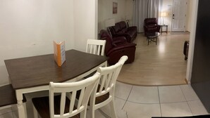 A dining area with a table and chairs, a living room with a sofa and chairs, and a door in the background. - Close To Beach, 3Bdrm / 2 Bath Duplex (Nokomis)