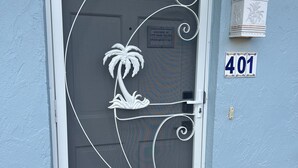 A door with a decorative metal design, a palm tree motif, and a sign reading "Welcome to 401". - Close To Beach, 3Bdrm / 2 Bath Duplex (Nokomis)