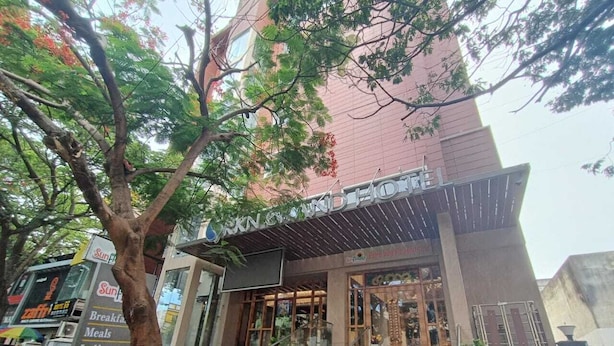 A building with a signboard for 'Sunrise Restaurant' and 'Sunrise Cafe'. - RKN Grand Hotel (Puducherry)