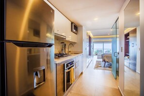 Una cucina moderna con elettrodomestici in acciaio inossidabile, forno integrato e forno a microonde.