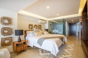 A modern bedroom with a bed, bedside table, lamp, and decorative wall art.
