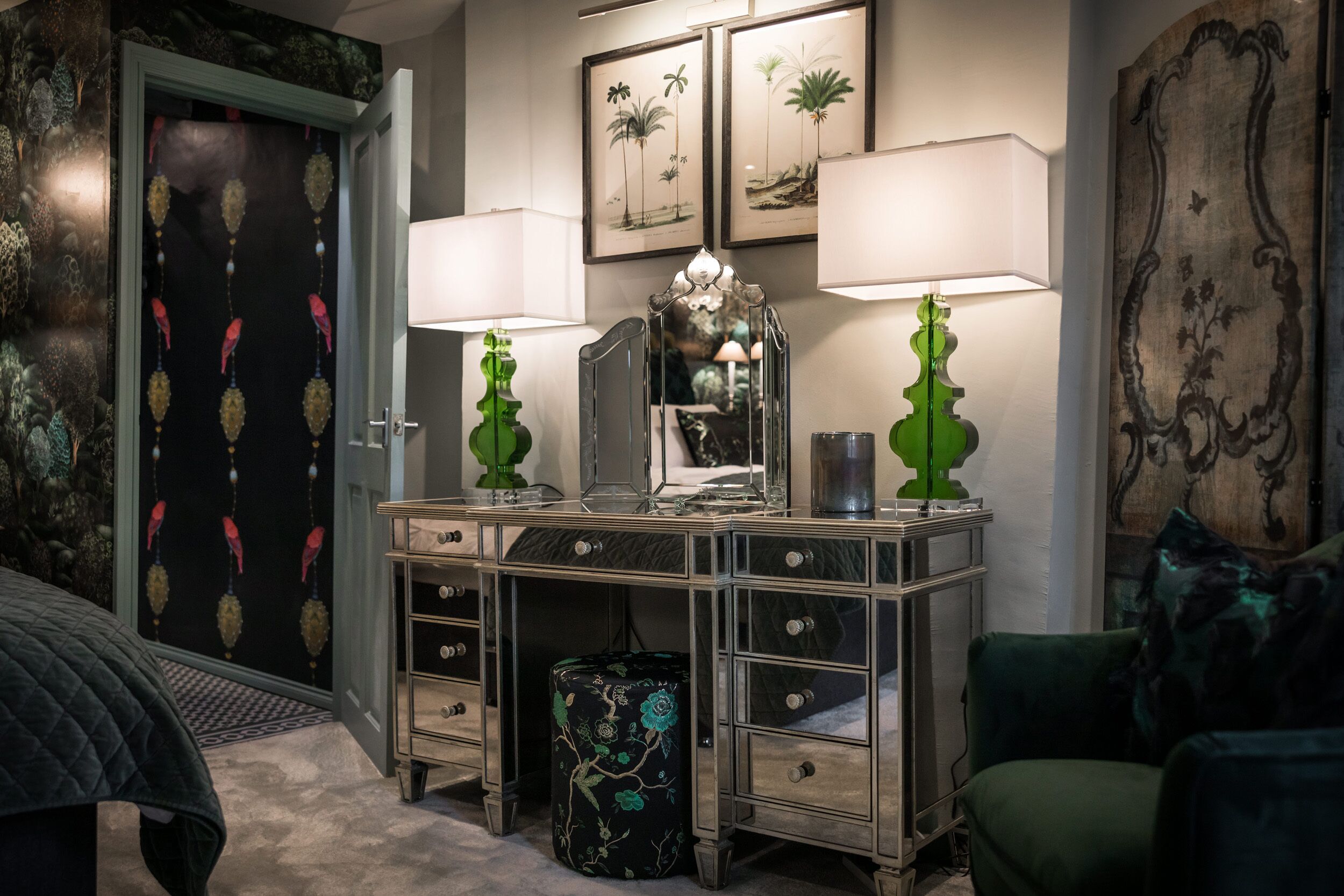 A bedroom with a bed, a dresser with drawers, a mirror, and two lamps.