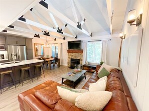 A modern living room with a leather sofa, a coffee table, and a fireplace. - Seasons 4 #140- Close to Canyon Lodge & The Villag (Mammoth Lakes)