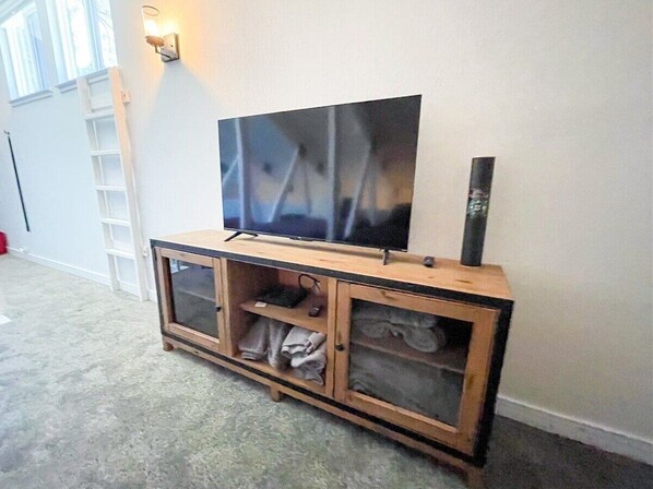 Un mobile in legno porta TV con televisore piatto e camino.