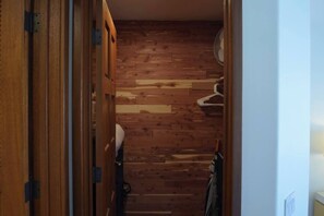 Un pasillo estrecho con paredes de madera y un ventilador de techo blanco.
