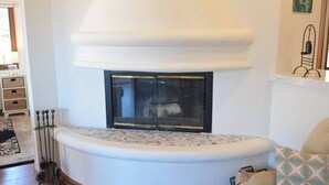 A corner fireplace with a white mantel, a black screen door, and a decorative metal railing. - Oceanfront view, plus corner patio and golf cart (Avalon)