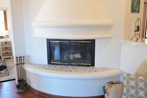 A corner fireplace with a white mantel, a black screen door, and a decorative metal railing. - Oceanfront view, plus corner patio and golf cart (Avalon)
