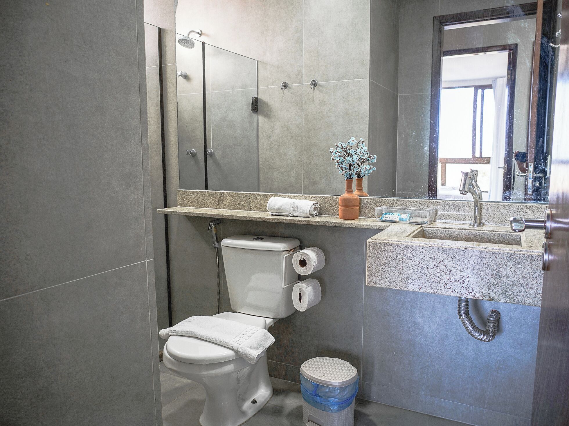 A modern bathroom with a toilet, sink, and shower.
