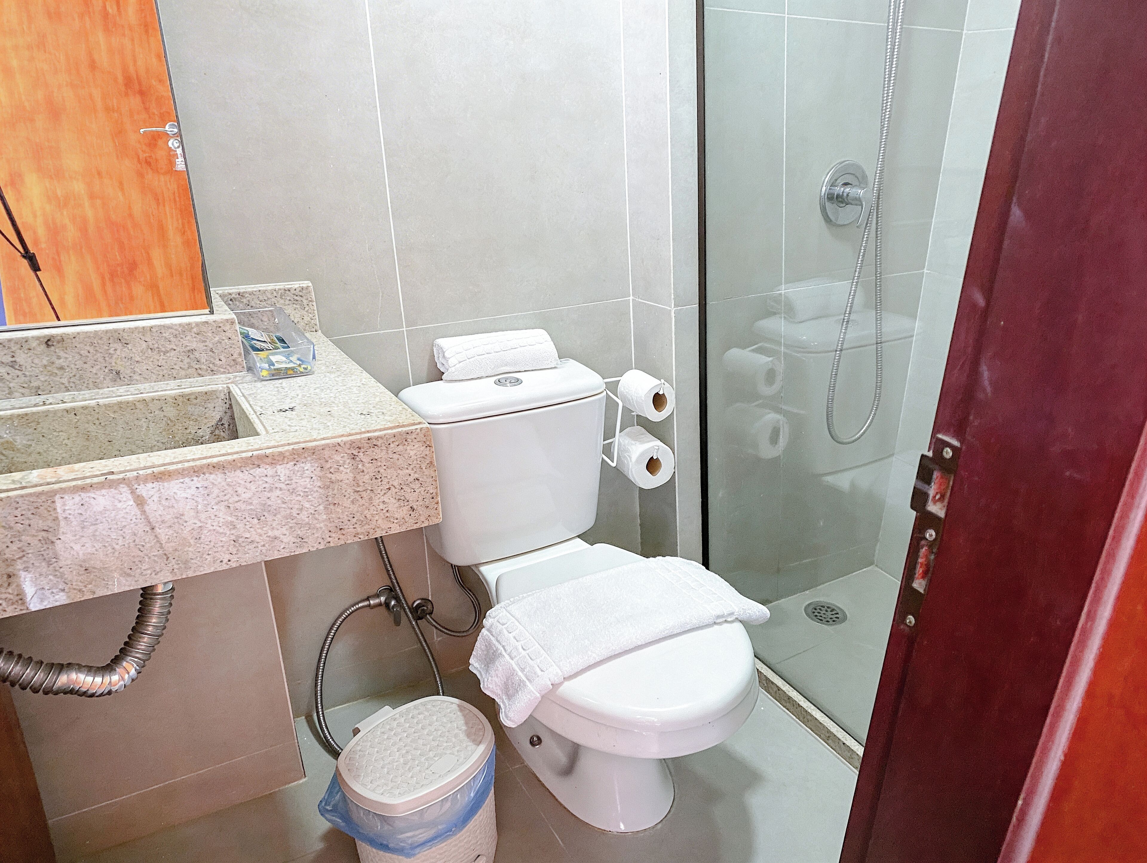 A bathroom with a toilet, a shower, and a sink.