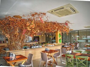 A restaurant with a bar area, wooden tables, and chairs.
