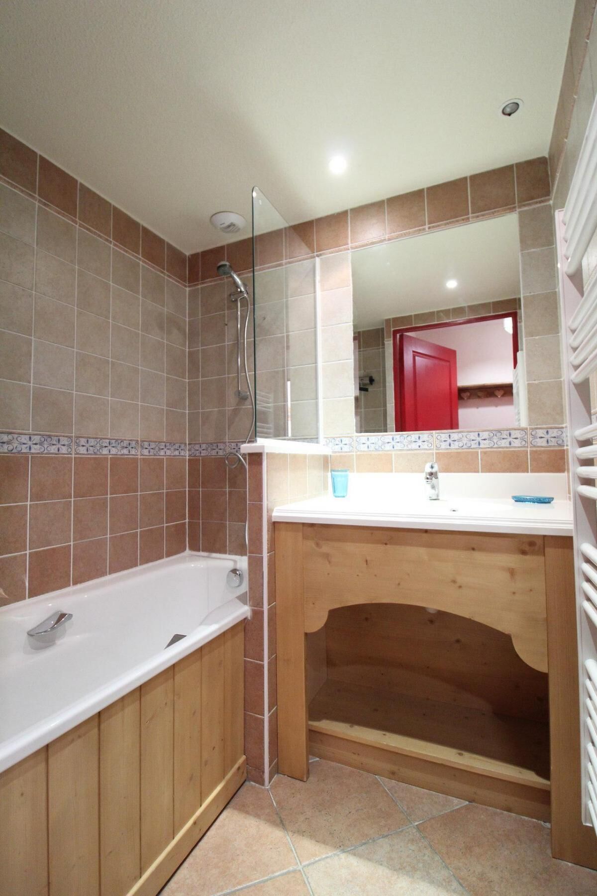 Un baño con tocador de madera, bañera blanca y ducha.