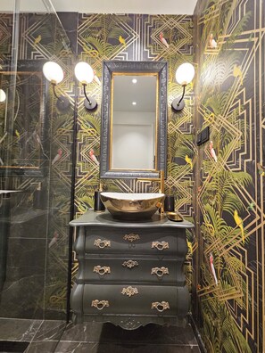 Bathroom features a large mirror, vessel sink, and ornate vanity.
