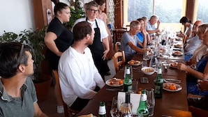 A group of people seated around a long dining table with various dishes and drinks. - Glamping at an Agriturismo in the Vineyard (Ortezzano)