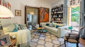 Una sala de estar con sofá, sillón, mesa de centro y estantería.