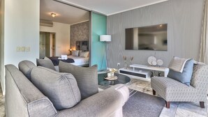 Een moderne woonkamer met een zithoek, een salontafel en een televisie.