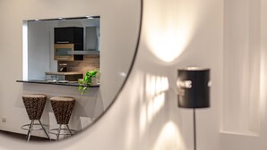 Eine moderne Küche mit dunklen Schränken, einer Arbeitsplatte und zwei Hocker mit Leopardenmuster.