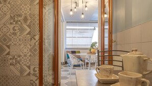 A modern kitchen with a dining area, featuring a coffee station with cups and a kettle. - Kitty Apartment   to visit S. Pietro (ROMA)