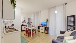 Moderni huoneisto, jossa on keittiö, ruokailutila, olohuone ja televisio.